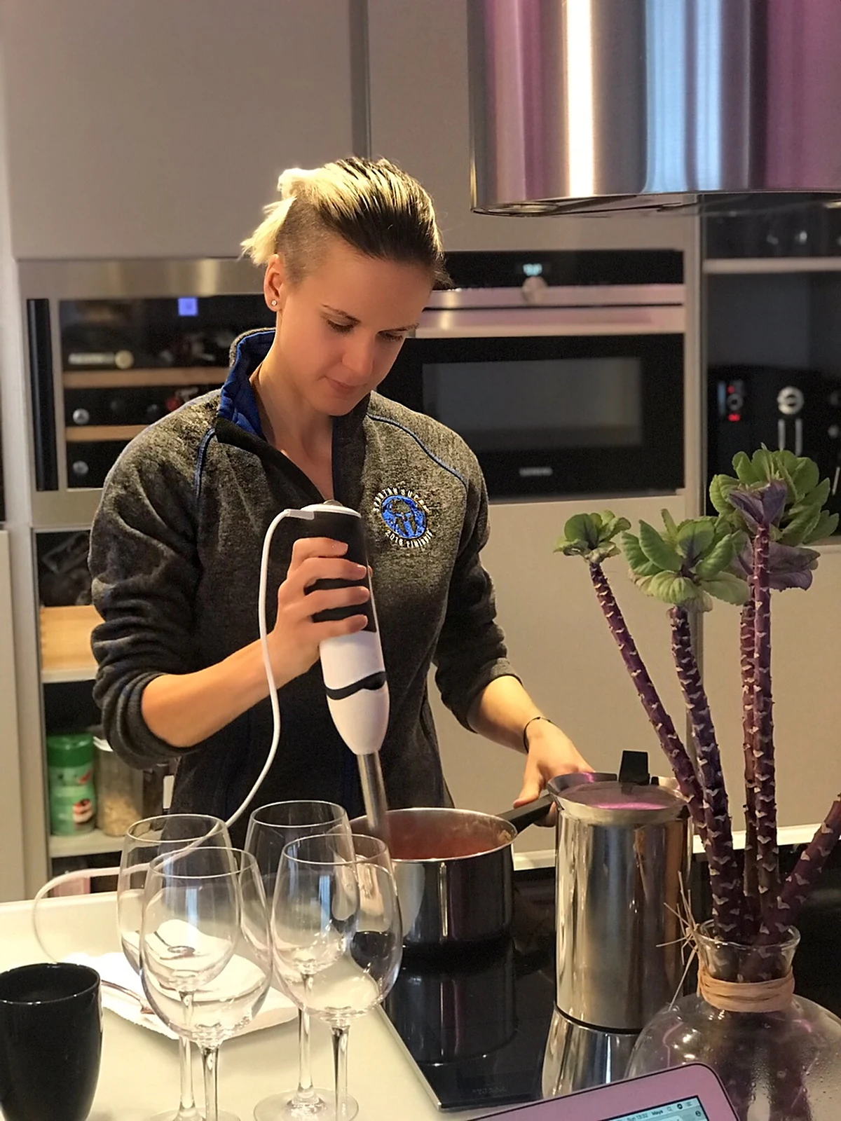 Olga preparing food in her kitchen, blending a soup